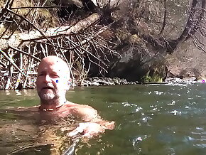 naked uncut bear chilling in the matter of the river
